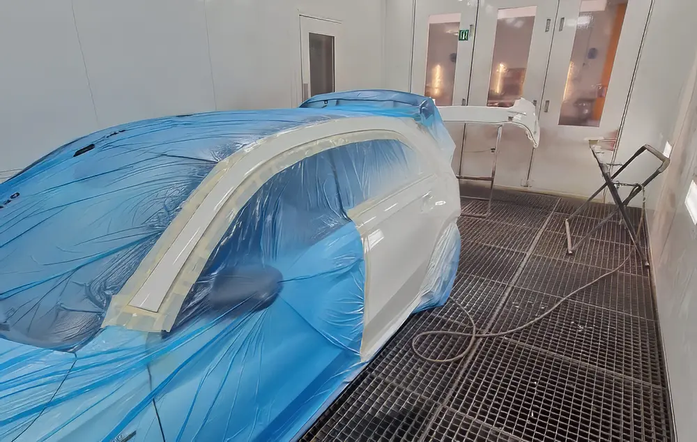 Un hommme travaillant soigneusement sur de la carrosserie