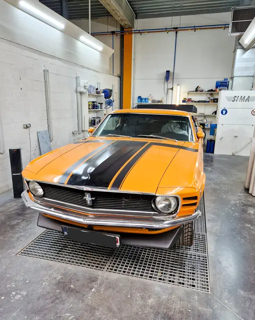 Carrossier en train de poncer un véhicule ancien